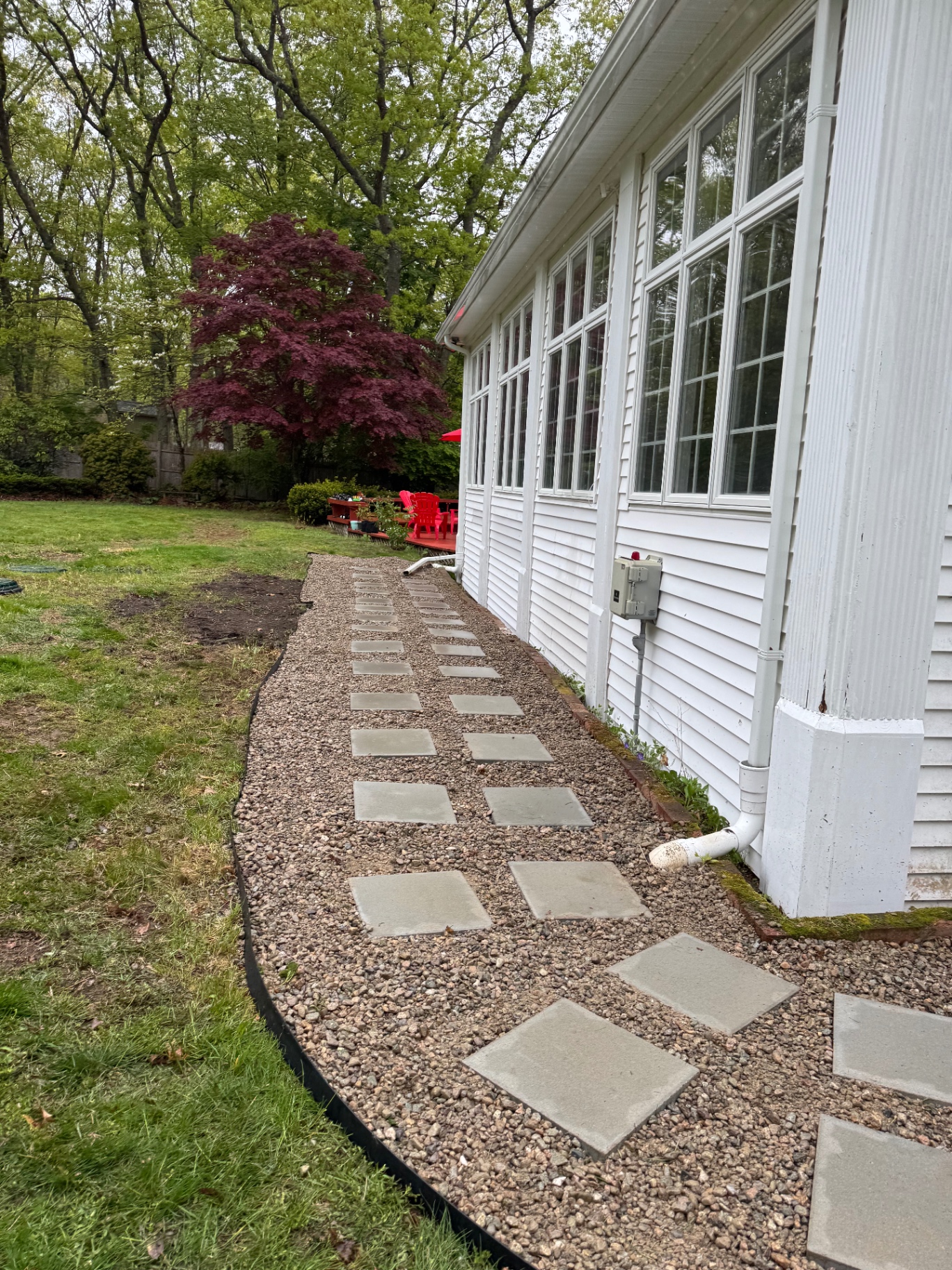 Gravel side path with stepping stones beside a white home