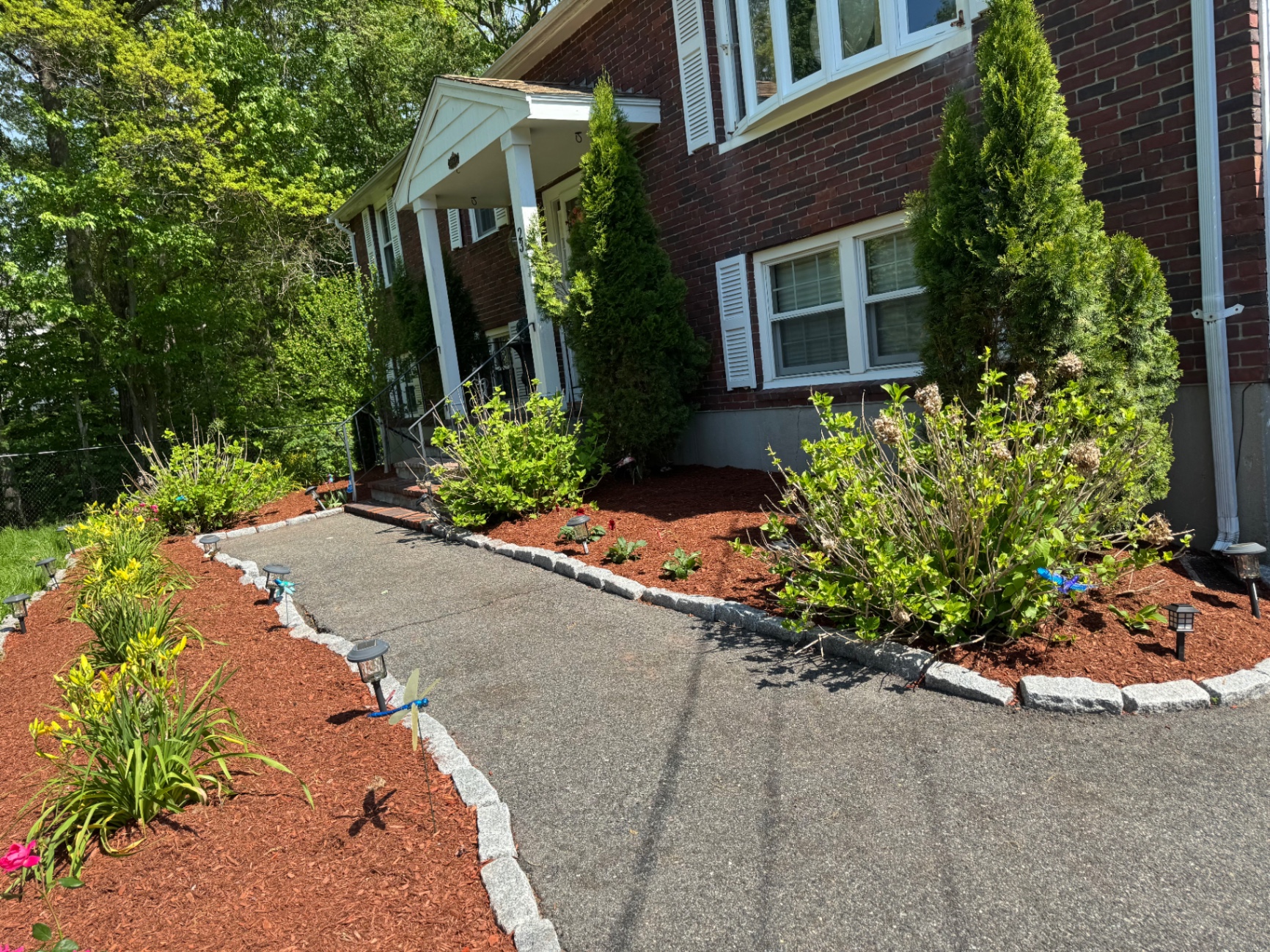 Front walkway landscape refresh with daylilies, shrubs, and red mulch