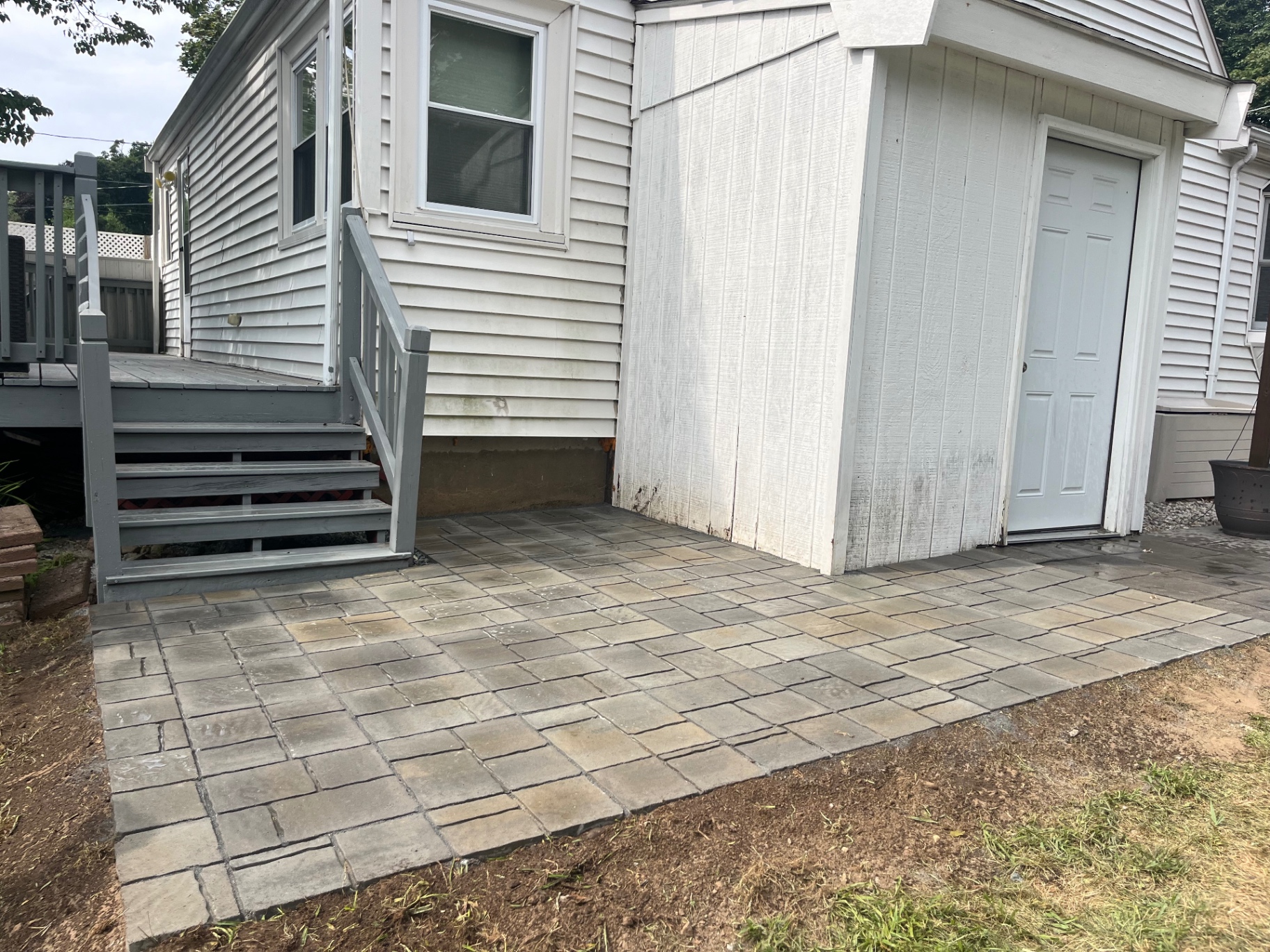 New paver patio installed at a side entry off the deck