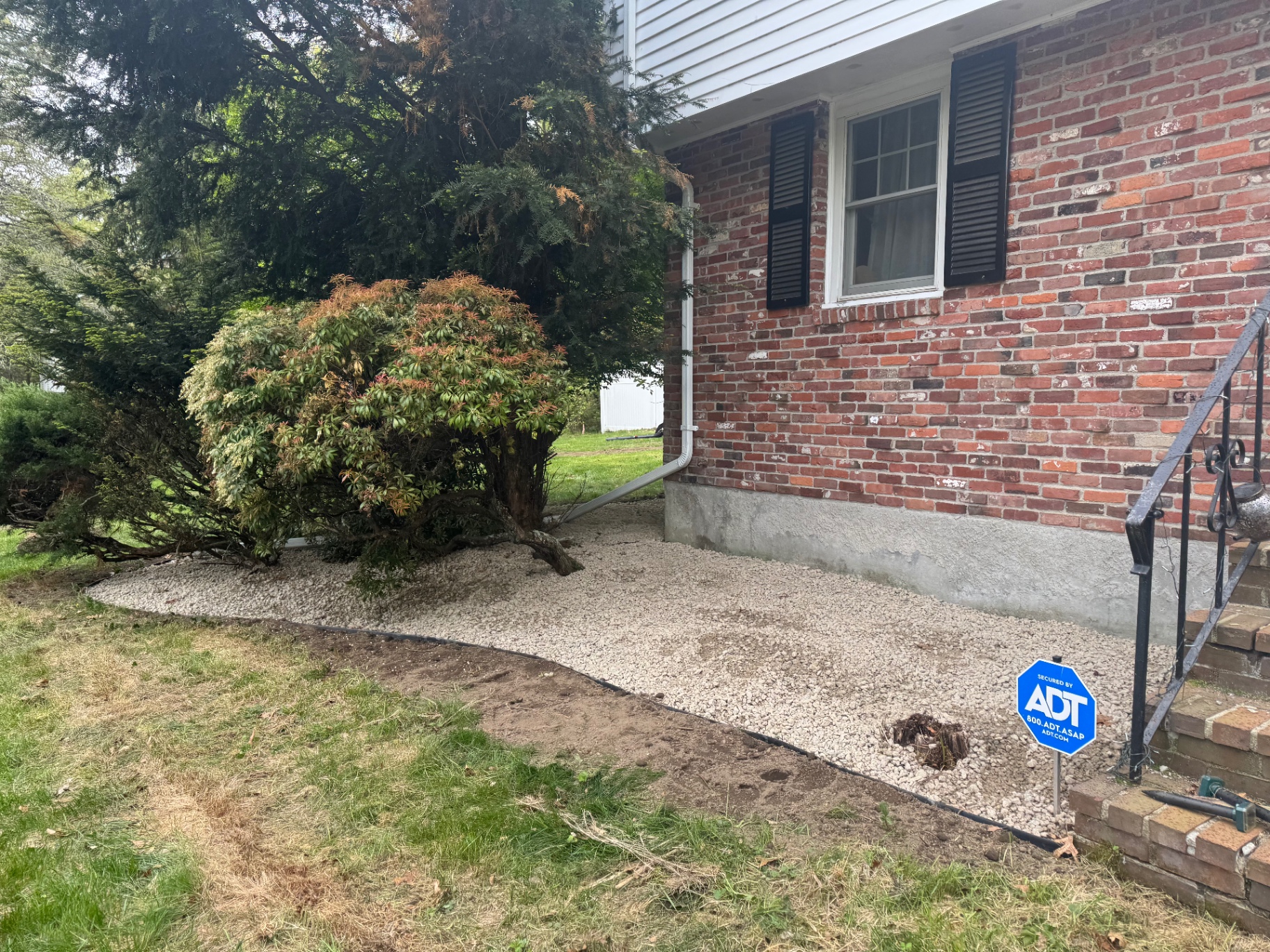 White stone foundation bed beside a brick home